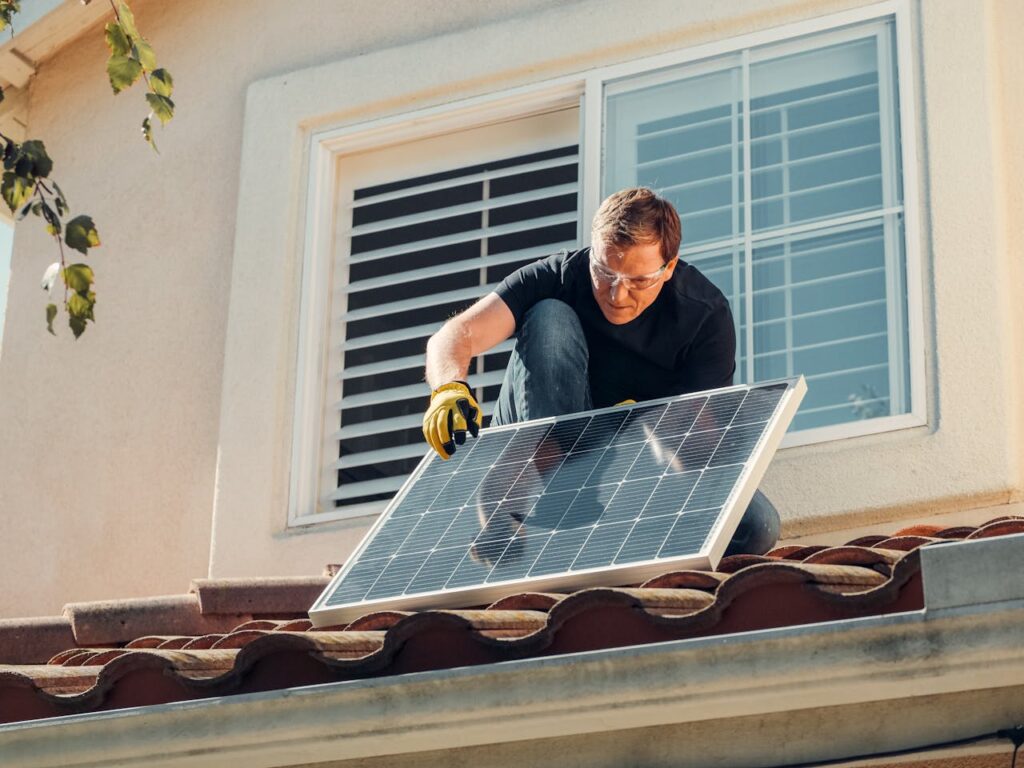 Mann installiert eine PV-Anlage Balkonkraftwerk auf Flachdach Ist das möglich