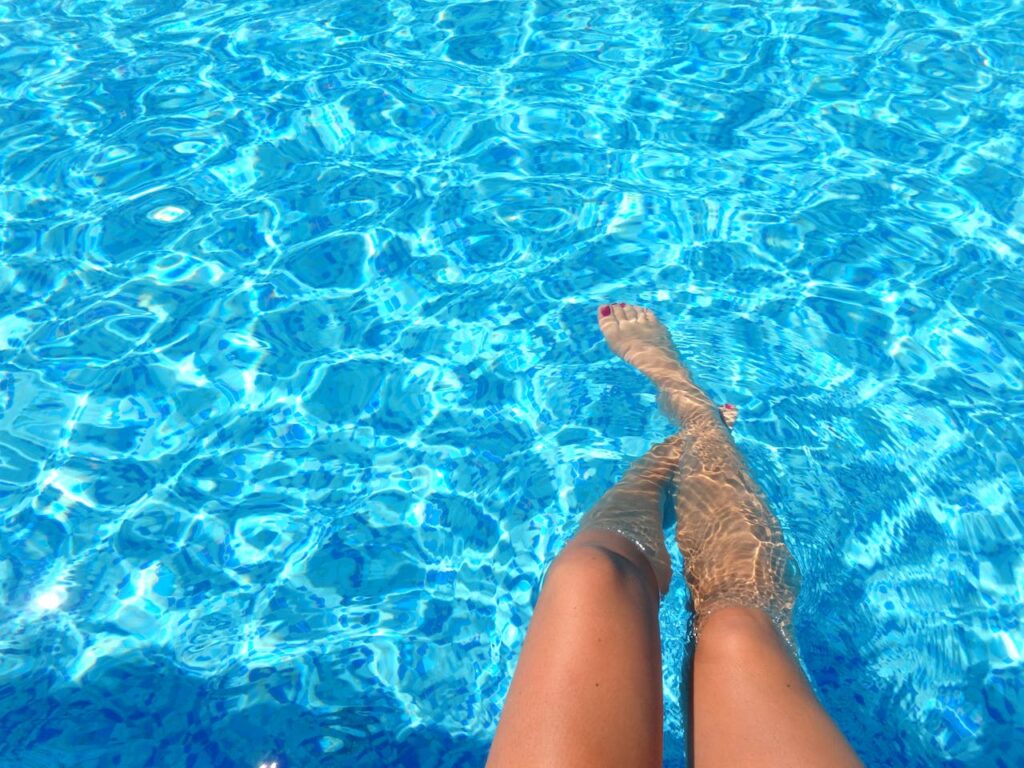 Frau am Pool Beckenrand Beine Füße Pool im Garten trotz wenig Platz – So klappt’s auch im kleinen Garten
